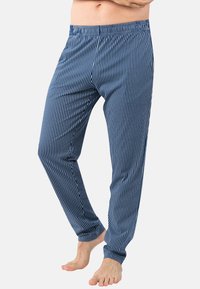 Pantalons de pyjama rayés bleus avec une taille élastique, des jambes fuselées et une texture douce, présentant de fines rayures blanches sur un fond bleu foncé.