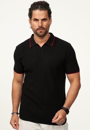 Schwarzes Poloshirt mit kurzen Ärmeln, strukturiertem Stoff, roten Akzenten am Kragen und an den Ärmelbündchen sowie einer klassischen Drei-Buttons-Leiste.