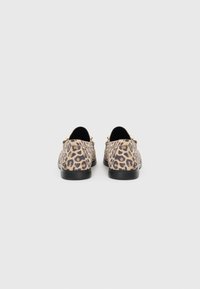 Mocassini con stampa leopardata, upper texture, suola nera e hardware dorato sui lati. Design piatto e punta arrotondata.