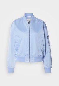 Jasnoniebieska kurtka typu bomber wykonana z błyszczącego nylonu. Posiada przedni zamek błyskawiczny, dwie boczne kieszenie oraz ściągacze przy mankietach i na dole. Minimalistyczne detale designu.
