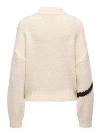 Pull en maille crème avec épaules tombantes, poignets et ourlet côtelés, et un détail d'une bande noire sur la manche droite.