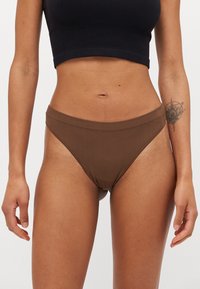 Brown ribbed bikini bottom with a mid-rise waistband and minimal coverage. Smooth texture and seamless edges. No visible hardware or accents.
