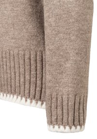 Beige Wollpulloverärmel mit einem gerippten Bündchen und weißen Akzenten, die eine sanfte Textur und ein dezentes Muster zeigen.