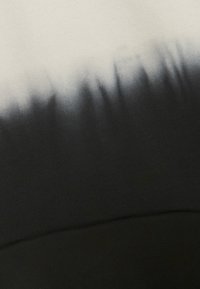 Tessuto in gradiente nero e crema con una texture morbida; presenta un motivo ombre che passa dal chiaro allo scuro.