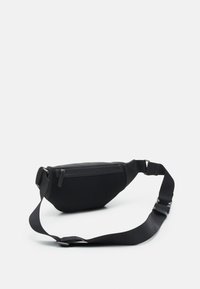 Black fanny pack with a textured surface, featuring a zippered pocket, adjustable strap, and a compact, curved shape.
