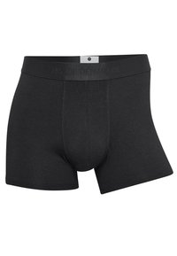 Black cotton boxer briefs with a flexible waistband, featuring a central pouch and short legs for a snug fit. Brand name embossed on the waistband.