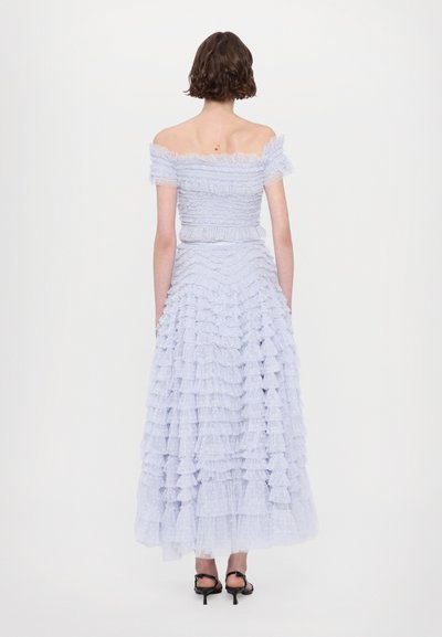 Abito azzurro chiaro con spalle scoperte, corpo aderente e gonna con balze a strati. Realizzato in tessuto trasparente con dettagli testurizzati e una leggera lucentezza.