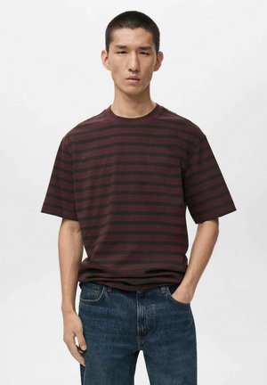 Striped t-shirt in dark burgundy and black, featuring a relaxed fit, short sleeves, and a round neckline. Worn with blue jeans.