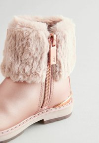 Rosa Kunstleder-Ankle-Boot mit einem flauschigen, hellrosa Pelzaufschlag. Verfügt über einen kupferfarbenen Reißverschluss und ein metallisches Detail entlang der Ferse.