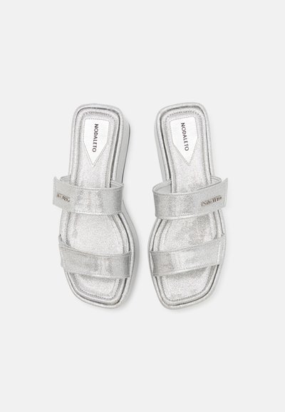 Silver glitter-sandaler med två breda remmar, fyrkantig tå och texturerad sula. Varumärket 'Nodaleto' syns på remmarna.