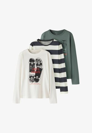 Tri majice z dolgimi rokavi: bela z grafiko skateboarda in napisom "SKATE FRIDAYS", črno-bele črte ter enobarvna zelena z majhnim tiskom.