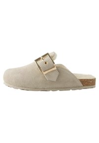 Beige mocka klack med rund tå, justerbar guldbuckle och strukturerad korksula. Fodrad insida för extra komfort.
