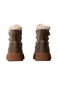 Bruine suède enkelbootjes met een zachte witte bontkraag, vetersluiting en een gestructureerde rubberen zool. De achterkant benadrukt de hak en de stiksels.