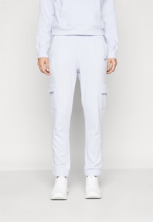 Light blue sweatpants made of soft fabric, featuring a relaxed fit, elastic cuffs, and two side cargo pockets.