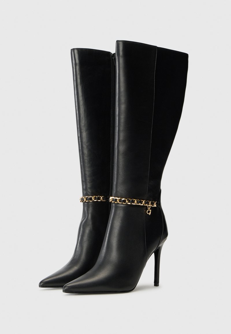 Zwarte leren kniehoge laarzen met spitse neuzen, stilettohakken en een gouden kettingaccent rond de enkel. Voorzien van een zijrits.