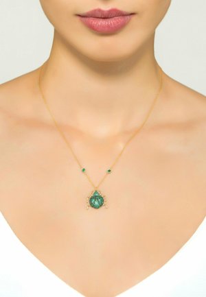 Collana d'oro con un ciondolo a forma di coleottero verde e due piccoli accenti verdi. Il coleottero presenta un design testurizzato, che mette in mostra dettagli intricati.