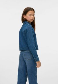 Denimjacka i mörkblått med en strukturerad passform, framfickor och knäppärmar, i kombination med matchande högmidjade denimbyxor.