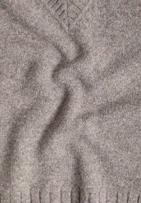 Maglione marrone in maglia con scollo a V, caratterizzato da un tessuto morbido e testurizzato e da motivi sottili; orlo e polsini a coste.
