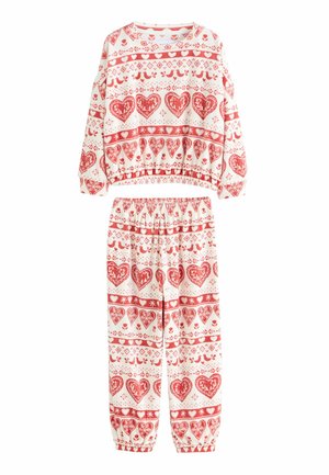 Rød og hvid mønstret loungewear-sæt med hjerter, fugle og blomsterdesigns. Toppen har rund hals; bukserne har elastik i taljen og ved håndleddene.