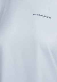 Ljusblå kortärmad skjorta i ett glatt tyg, med en liten "ENDURANCE" logotyp i grått nära halslinningen.