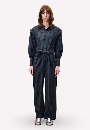 Lange, donker gestreepte jumpsuit met knopen aan de voorkant, brede mouwen, een strikceintuur en een borstzak, gecombineerd met zilveren schoenen.