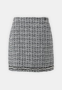 Tweed mini sukňa v čiernej a bielej farbe s textúrovaným vzorom, s okrajom ozdobeným perlami a priliehavým strihom.
