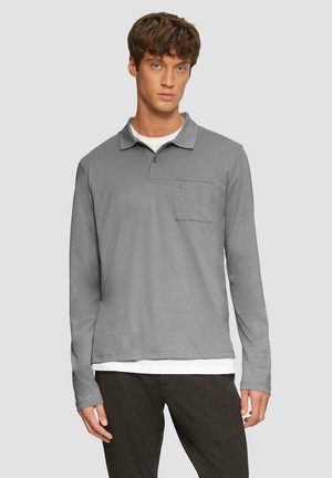 Langarm polo shirt van grijs katoen met een kraag, knoopsluiting en een borstzak. Gelaagd over een witte ronde hals t-shirt.