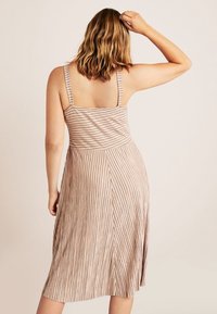 Vestido midi a rayas marrón con tirantes finos, corsé ajustado, falda acampanada, hecho de un tejido suave con una textura sutil y líneas verticales.