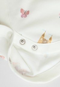 Katoenen rompertje met een witte basis, versierd met roze vlinders en een kasteelontwerp. Inclusief zilveren drukknoopsluitingen onderaan voor gemakkelijk aankleden.