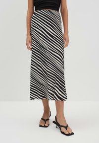 Gonna a righe bianche e nere con un design fluido, di lunghezza media, realizzata in tessuto leggero, con una vita comoda e una silhouette snella.