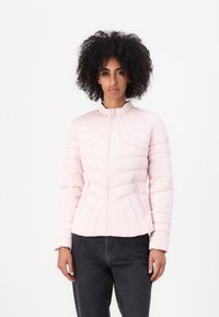 Light pink puffer jacket with a zip closure, features a high collar, diamond quilted texture, and two front pockets. Accents include button details.