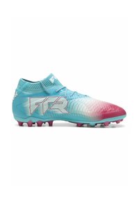 Botas de fútbol de color azul claro con degradado rosa, parte superior texturizada, cuello tipo calcetín y tacos rosas. Presenta un logotipo llamativo en el lateral.