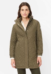 Quilted olivgrüner Mantel mit hohem Kragen, Reißverschluss vorne und Seitentaschen. Mit strukturiertem Rautenmuster und elastischen Bündchen.