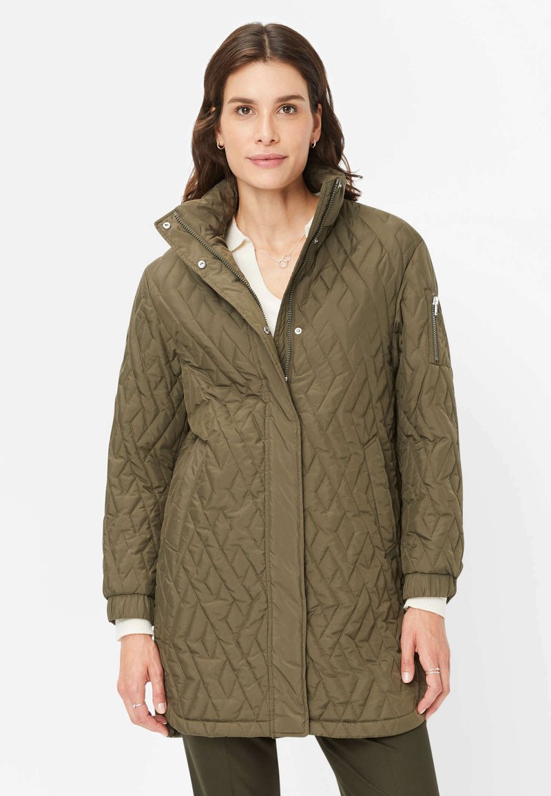 Quilted olivgrüner Mantel mit hohem Kragen, Reißverschluss vorne und Seitentaschen. Mit strukturiertem Rautenmuster und elastischen Bündchen.