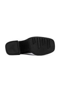 Suola di scarpa nera con una superficie testurizzata, caratterizzata da scanalature orizzontali e un bordo rialzato. Gli accenti includono un bordo pulito e liscio.