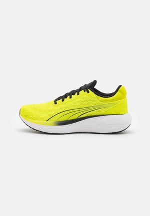 Zapatilla de running verde lima con parte superior de malla transpirable, acentos negros y una suela blanca acolchada con la marca "PROFOAM" en el talón.