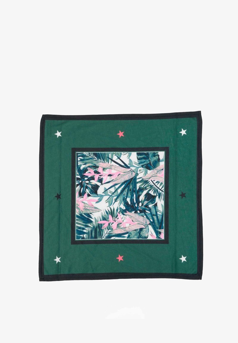 Coperta decorativa verde con un motivo centrale di foglie tropicali in rosa e blu, bordata da un telaio scuro e accentata da stelle in rosso, bianco e nero.