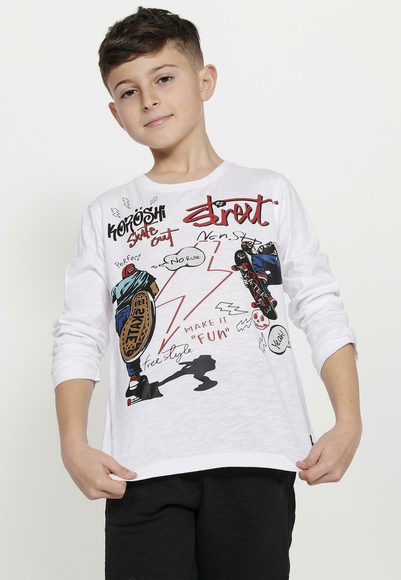 Witte lange мouw T-shirt met kleurrijke grafische prints van skateboardfiguren, dynamische tekst en abstracte vormen. Zacht, katoenen materiaal.