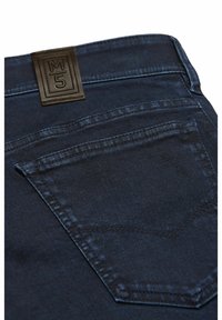 Donkerblauwe denim jeans close-up met de achterzak en zwarte leren merkpatch met het "M5" logo op de tailleband.