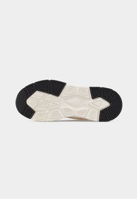 Σόλα παπουτσιού με μαύρο και άσπρο ελαστικό πέλμα που διαθέτει γεωμετρικά σχέδια και υφασμένες περιοχές κράτησης για πρόσφυση και ανθεκτικότητα.