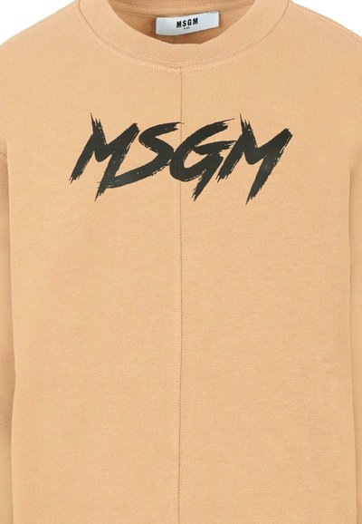 Felpa in cotone beige con logo "MSGM" nero in lettera a pennellate. Collo rotondo e polsini a coste. Texture liscia, design casual.