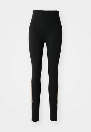 Black leggings with a high waistband, featuring gold accents along the sides and a smooth, stretchy fabric texture.