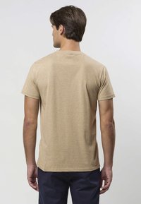 Kurzärmeliges T-Shirt in hellem Beigeton mit einem glatten, strukturierten Stoff. Verfügt über einen klassischen Rundhalsausschnitt und eine lockere Passform.