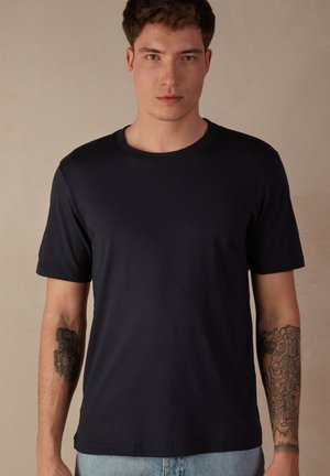 Navyblaues Rundhals-T-Shirt aus Baumwolle, mit kurzen Ärmeln und einer glatten Textur. Minimalistisches Design ohne Muster oder Logos.