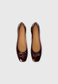 Ballerines en cuir verni bordeaux avec un bout arrondi, une surface lisse et un détail en nœud décoratif à l'avant. Doublure intérieure beige.