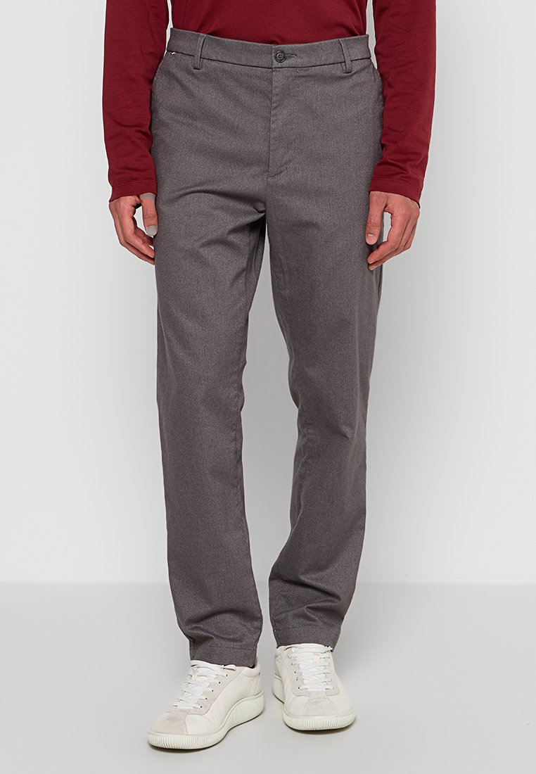 Grau Hose aus glattem Stoff, mit geradem Bein, zwei Vordertaschen und Knopfverschluss, kombiniert mit weißen Sneakers.