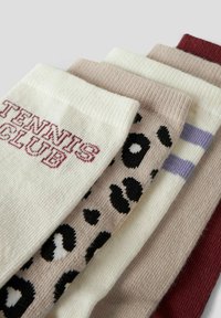 Fünf Paare Socken in gemischten Designs: weiß mit "TENNIS CLUB" in maroon, beige mit schwarzen Leopardenflecken und gestreiften Akzenten. Verschiedene Texturen.