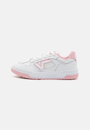 Baskets de sport blanches avec des accents roses, dotées d'une semelle texturée, d'un bout rond et d'un système de laçage. Le côté présente un motif découpé décoratif.