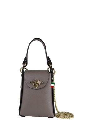 Small taupe leather handbag with top handle, gold bee decoration on flap, Italian flag charm, and a gold chain strap coiled beside it.