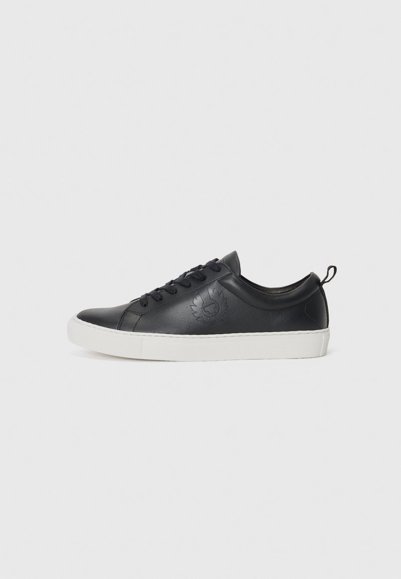 Fekete bőrsneaker lekerekített orral, fehér gumitalppal, fűzős elejével és dombornyomott logó részlettel az oldalon. Simább textúrájú.